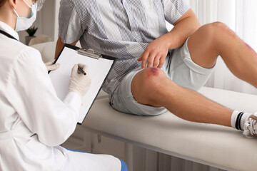 Doctor examining man with bruises in clinic