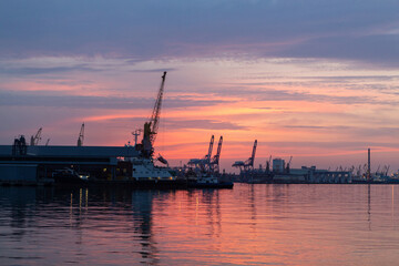 Fototapeta na wymiar sunset in industrial landscape of commercial seaport. Sunset at seaport.