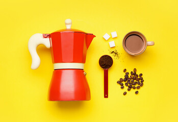 Geyser coffee maker, cup of coffee, spoon and beans on yellow background
