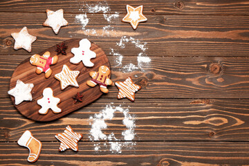 Composition with board of tasty Christmas cookies and sugar powder on wooden background