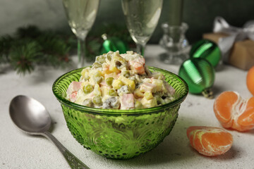 Bowl of Olivier salad on white table, closeup
