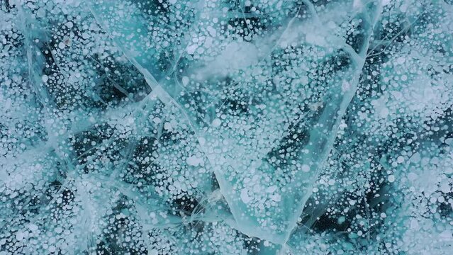 Frozen methane bubbles and cracks in the ice on Lake Baikal Siberia Russia. Natural cold background of ice. Winter abstract background. High quality 4k footage