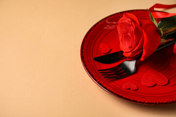 Table setting for Valentine's Day with rose and hearts on beige background, closeup