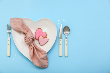 Table setting for Valentine's Day with pink hearts on blue background