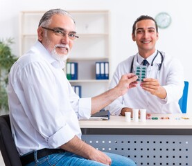 Old man visiting young male doctor