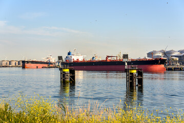Large tanker ships being unloaded in a oil terminal at sunset