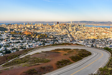 Elevated view of San Francisco downtown at sunset in autumn. A winding road is in foreground.