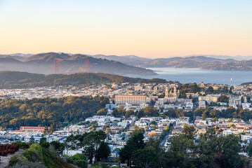 Naklejka premium Elevated view of a residential district of San Francisco at sunset in autumn. The Golden Gate bridge and the bay are in background.