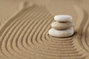 Japanse zen-tuinmeditatie, stenen achtergrond met stenen en lijnen in het zand voor ontspanning, balans en harmonie, spiritualiteit of wellness-spa, rustige pastelbeige kleur.