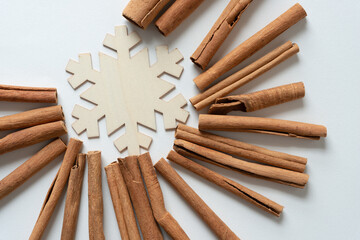 wooden snowflake shape and cinnamon sticks all around