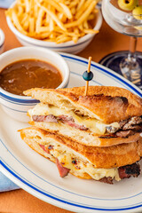 Reuben Sandwich. Classic traditional American sandwich. Pastrami and corned beef on grilled rye bread, melted Swiss cheese, sauerkraut, topped with thousand island dressing served french fries.