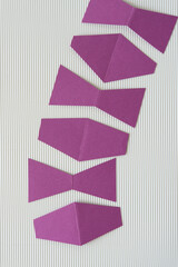 creased purple paper cutouts on corrugated paper