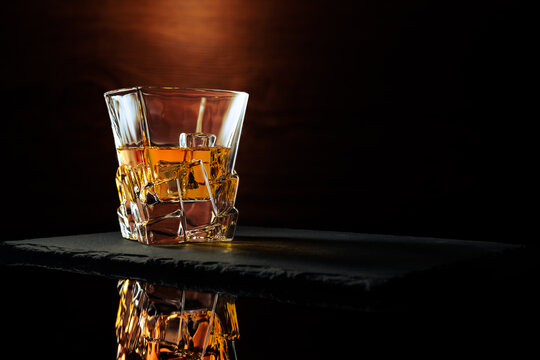 Whiskey Glass Reflection on stone and wood backdrop