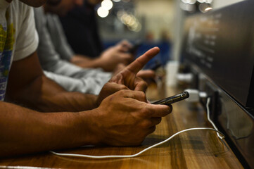 manos de hombres con teléfonos celulares conectados trabajando, en redes sociales o de ocio - obrazy, fototapety, plakaty