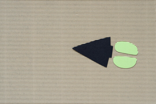 Black Paper Arrow With Colon On Beige Corrugated Paper