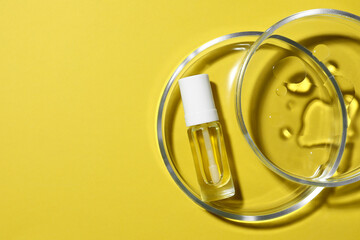 Petri dishes with bottle on yellow background, top view. Space for text