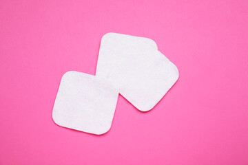 Cotton pads on pink background, flat lay