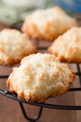 Closeup of fresh homemade coconut macaroons cooling on a rack (Very shallow depth of field, Focus on the front of the cookie in the front)