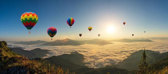 Colorful hot air balloons flying above mountain at sunrise sky background. Travel natural...