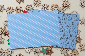 two holiday cards on a bed of wooden snowflakes and paper