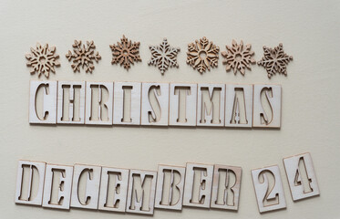christmas december 24 and wooden snowflakes on plain paper