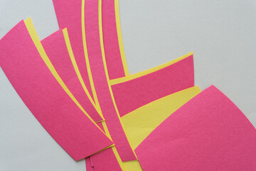Naklejka premium pink and yellow construction paper shapes on a plain paper background