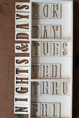 nights and days of the week in stencil type on grungy work board - thursday abbreviated as thru