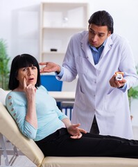 Fototapeta premium Old woman visiting young doctor dentist