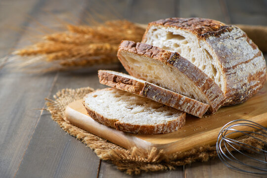 Sliced Sourdough Bread on wood board on wood background, homemade bakery