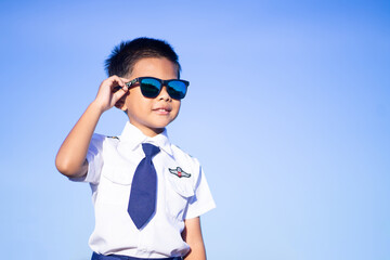 A boy wearing black glasses and a white pilot suit on a blue background