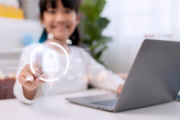 Child safety online. Little girl using laptop at home. icon of internet blocking app on foreground