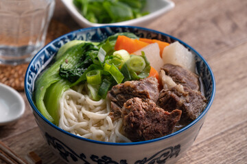 Beef noodle soup. Close up of Taiwanese famous food in a bowl on wooden table.