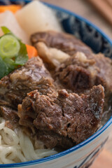 Beef noodle soup. Close up of Taiwanese famous food in a bowl on wooden table.