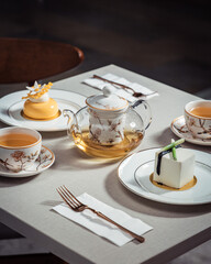 Tea time with French fine desserts on a table. High tea with petite gateau