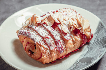 French Pastry on a plate with concrete background. French Croissant, Cinammon Roll, Cruffin, Bread Stick, Scones.