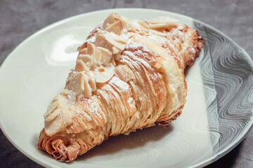 French Pastry on a plate with concrete background. French Croissant, Cinammon Roll, Cruffin, Bread Stick, Scones.