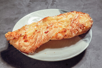 French Pastry on a plate with concrete background. French Croissant, Cinammon Roll, Cruffin, Bread Stick, Scones.