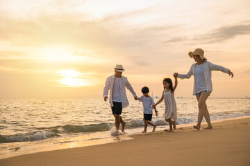 Happy family having fun running on a sandy beach at sunset time, Active parents and people father,...