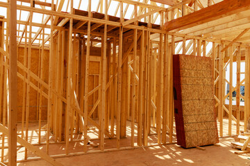 A house under construction is framed with beams.