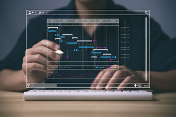 Male manager managing business planning project schedule in the office. Gantt chart showing on virtual screen.