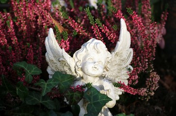 Kleiner Engel im Heidekraut auf dem Friedhof im Herbst