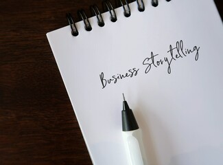 Pencil writing on notebook - Business Storytelling - refers to stories which business communicate...