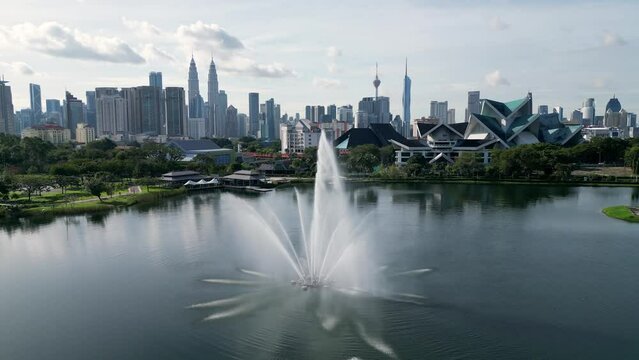 Slow move toward fountain at Taman Tasik Titiwangsa with background of KL city