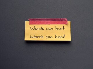 Yellow note stick on blue background with text Words can hurt Words can heal - to remind language...