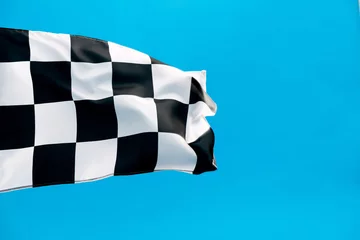  Checkered flag waving on blue background © xy