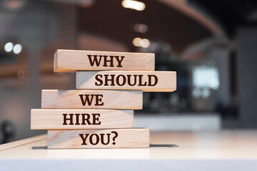 Wooden blocks with words 'Why should we hire you?'.