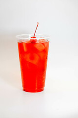 Red cherry lemonade with ice and cherries on a white background. view from above
