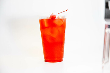Red cherry lemonade with ice and cherries on a white background. view from above