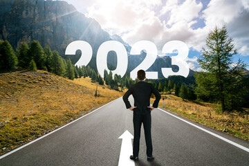 The 2023 New Year journey and future vision concept . Businessman traveling on highway road leading...