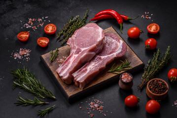 Fresh raw pork meat on the ribs with spices and herbs on a wooden cutting board